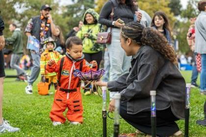 A child dressed up as an astronaut gets candy during Pacific Trick or Treat