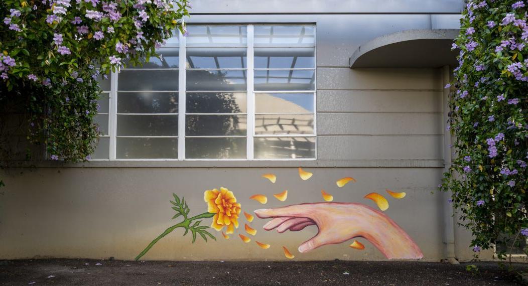 art mural of hand reaching a flower